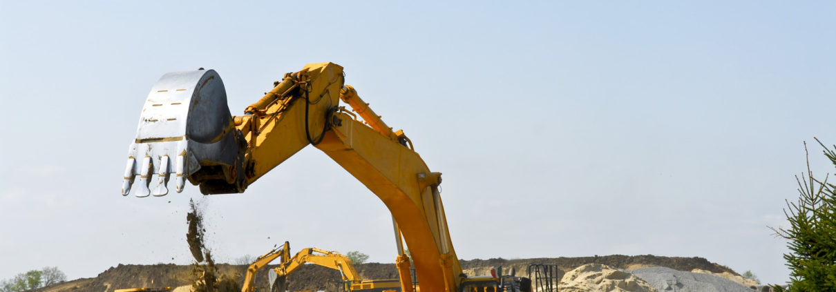 Yellow bulldozer machines digging and moving earth at construction site